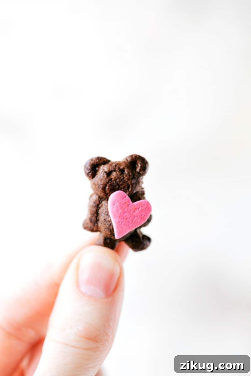 Sweet & Simple: 4 Valentine's Day Delights 9 An adorable mini Teddy Graham bear holding a red heart sprinkle, set against a blurred background. This cute and simple Valentine's Day treat is perfect for kids and adds a charming touch to any celebration.