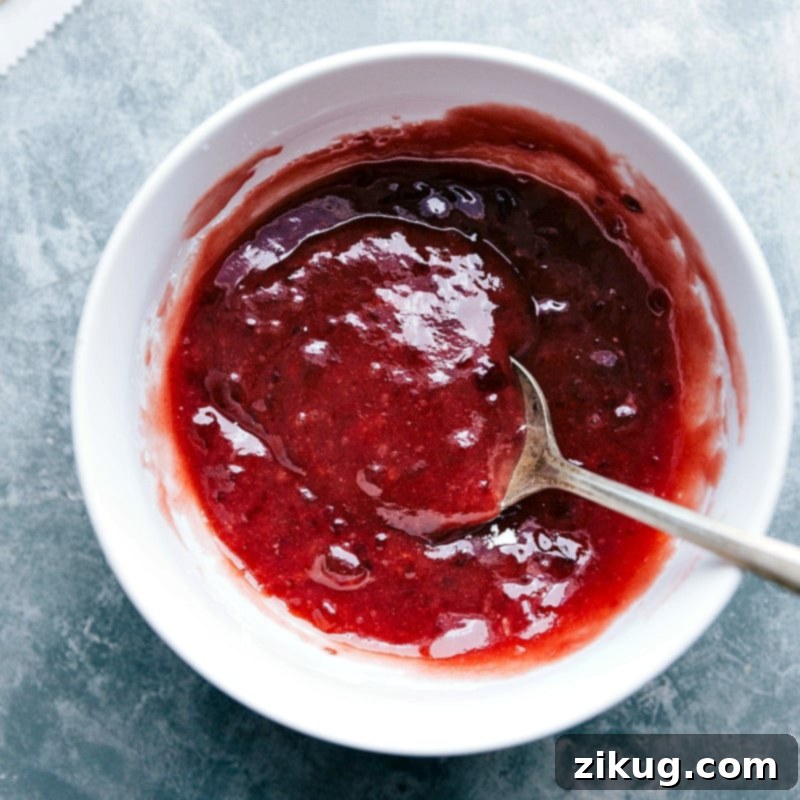 Succulent Strawberry Jam: The Heart of a Perfect Homemade Toaster Strudel A bowl filled with vibrant, glistening strawberry jam, ready to be used as a delicious filling for pastries.