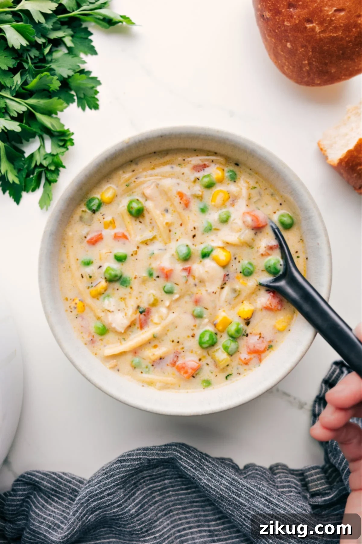 Flavorful Creamy Chicken Noodle Soup with Vegetables A steaming bowl of Creamy Chicken Noodle Soup, garnished with fresh herbs, ready to be enjoyed on a cozy evening.