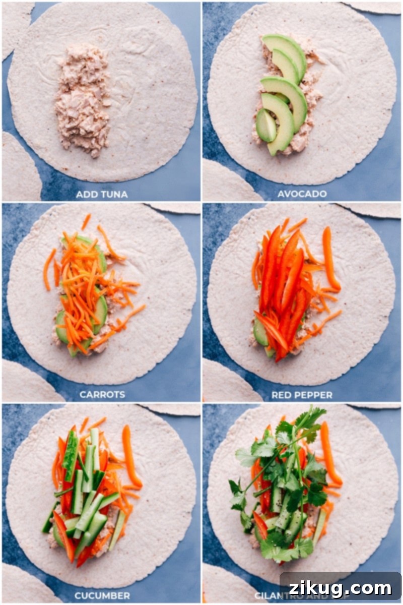 Detailed process shot illustrating the assembly of a Tuna Salad Wrap: creamy Sriracha tuna generously spread on a soft tortilla, followed by perfectly arranged slices of vibrant avocado, crisp matchstick carrots, refreshing red bell pepper, cool cucumber, and fresh cilantro sprigs, all seasoned with a sprinkle of salt and pepper.
