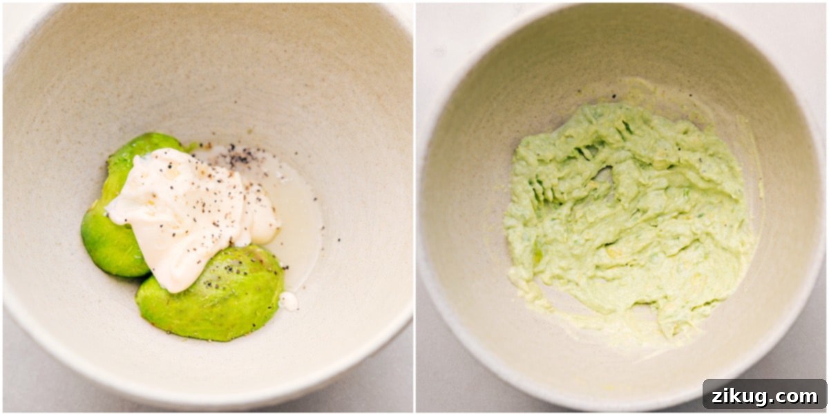 A bowl showing ripe avocado, lemon juice, mayonnaise, salt, and pepper being mashed together with a fork for a creamy avocado egg salad base.