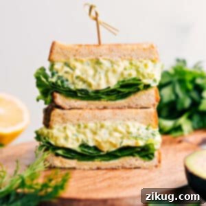 A beautifully presented bowl of creamy avocado egg salad with fresh herbs, ready to be served or added to a sandwich.