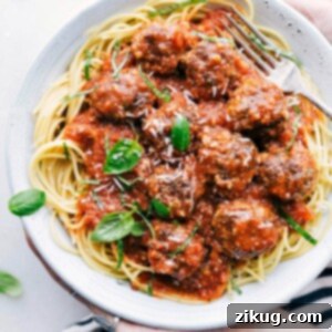 Close-up of a cheese stuffed meatball in marinara sauce.