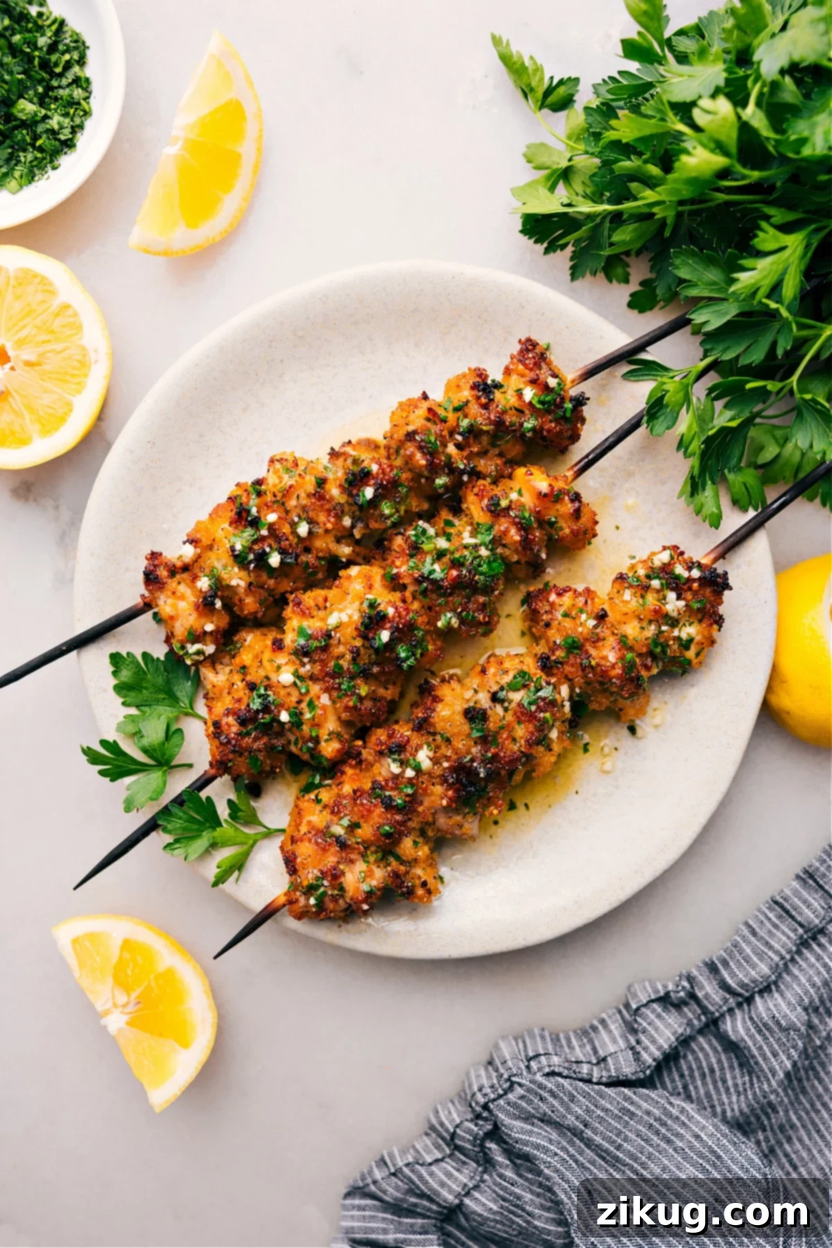 Golden brown, crispy Chicken Spiedini skewers garnished with fresh parsley, plated and ready to be served.