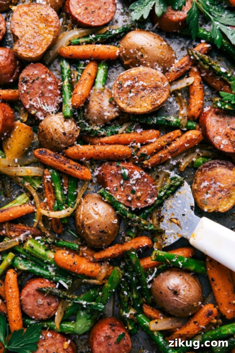 Potatoes and Sausage Sheet Pan Dinner Cooked to Perfection A sheet pan filled with a finished potatoes and sausage dinner, cooked to perfection and seasoned to enhance all the flavors, promising a delicious meal.