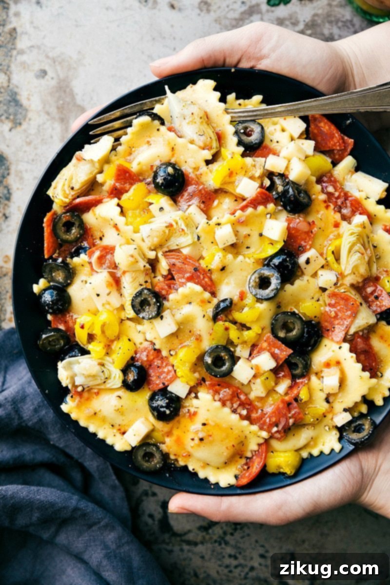 Vibrant Ravioli Salad 2 Delicious Four Cheese Ravioli Salad with pepperoni, provolone, artichoke hearts, and olives, garnished with fresh herbs