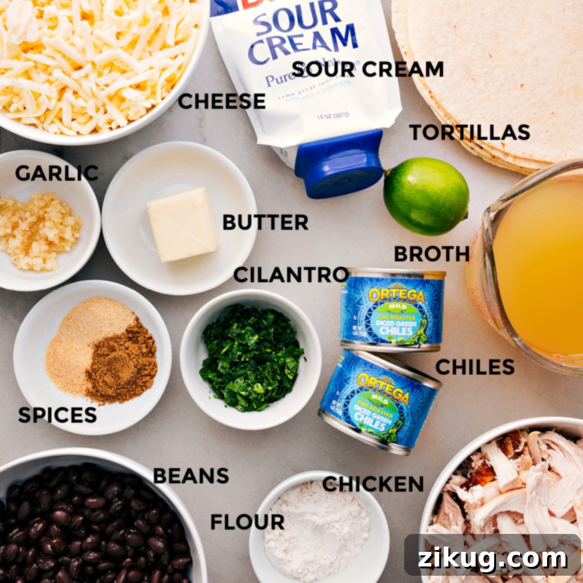 Key Ingredients For White Chicken Enchiladas All the ingredients prepped and ready for easy assembly—shredded cheese, soft flour tortillas, creamy sour cream, rich chicken broth, melted butter, fresh cilantro, mild green chiles, aromatic garlic, essential spices, protein-packed black beans, and shredded chicken, alongside flour for the roux.