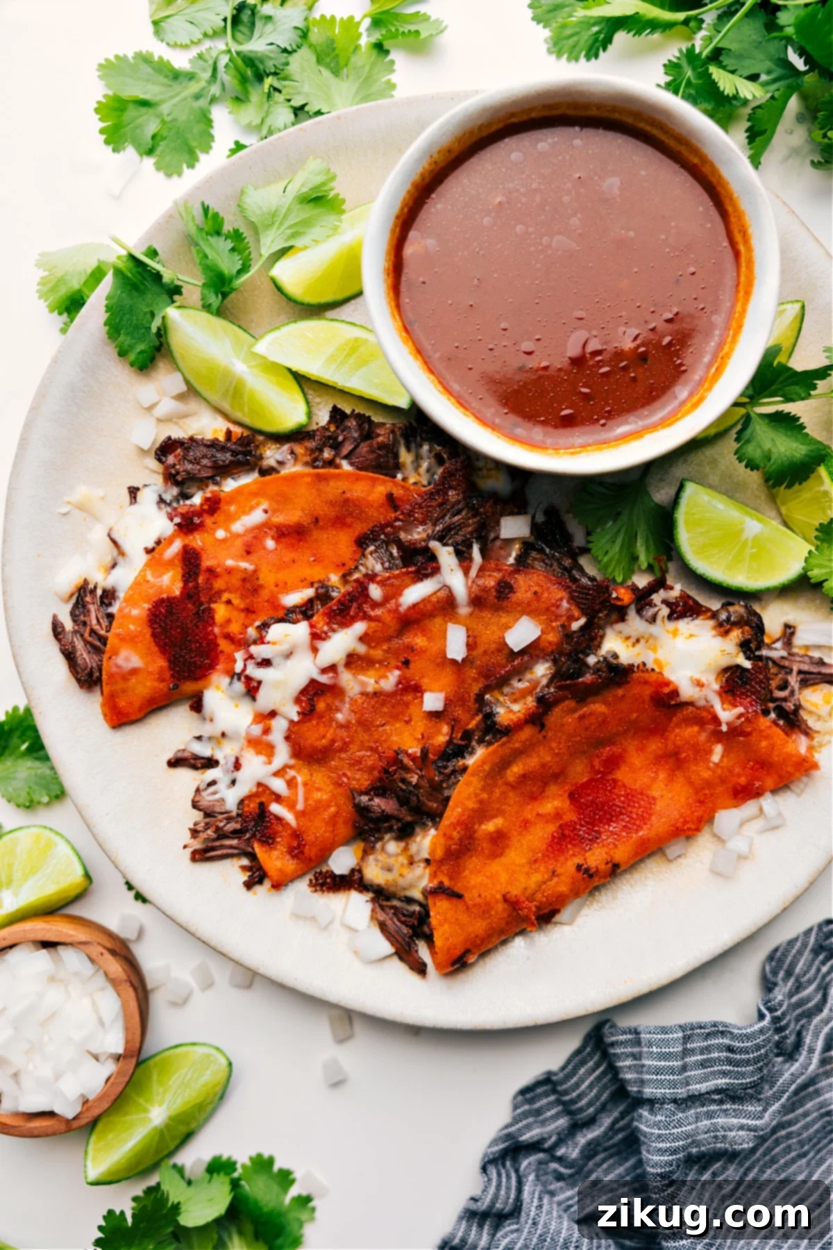 Delicious Quesabirria tacos served hot with a rich consomé for dipping.
