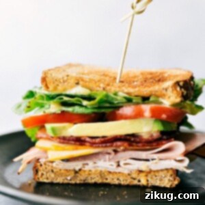 A beautifully presented Honey Bacon Club Sandwich, showcasing its generous fillings.