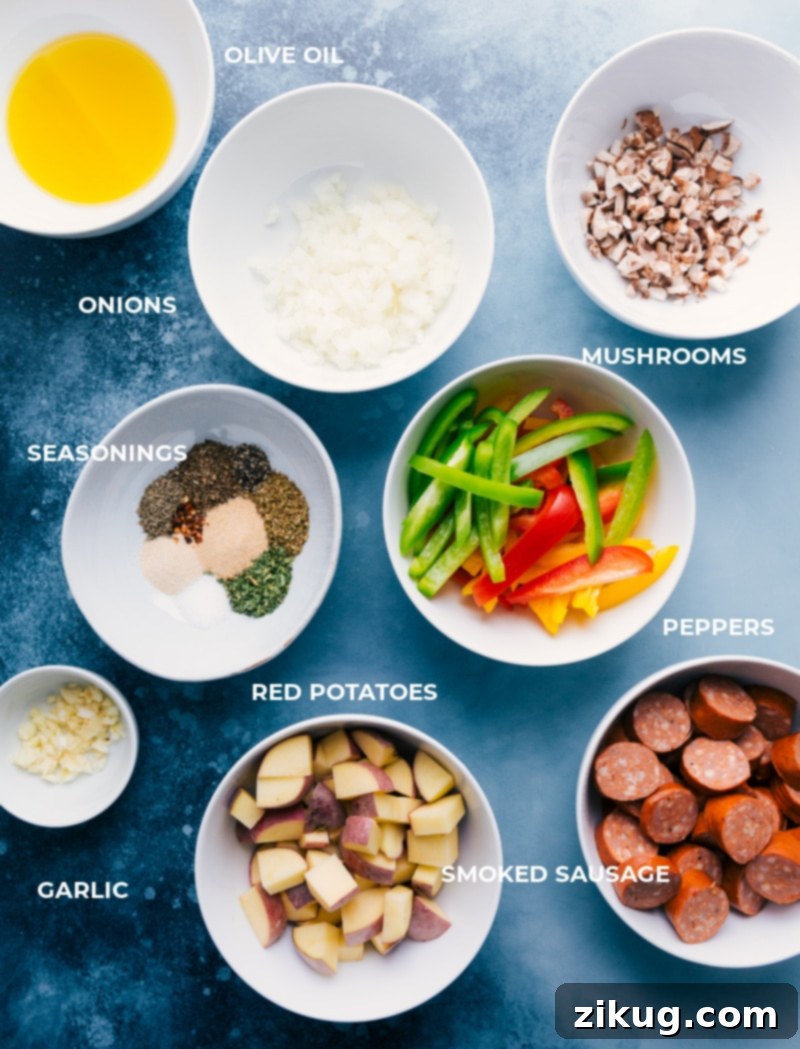 Key ingredients laid out for Foil Pack Italian Sausage and Veggies preparation. A vibrant display of fresh ingredients for Foil Pack Italian Sausage and Veggies, including sausage, bell peppers, potatoes, mushrooms, and spices.