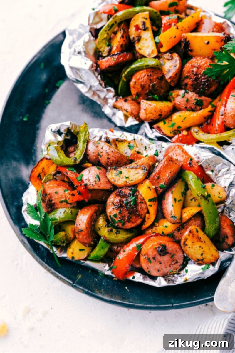 Ready-to-eat Foil Pack Italian Sausage and Veggies, a wholesome and satisfying meal. A single serving of cooked Foil Pack Italian Sausage and Veggies, presented on a plate after being removed from the foil.
