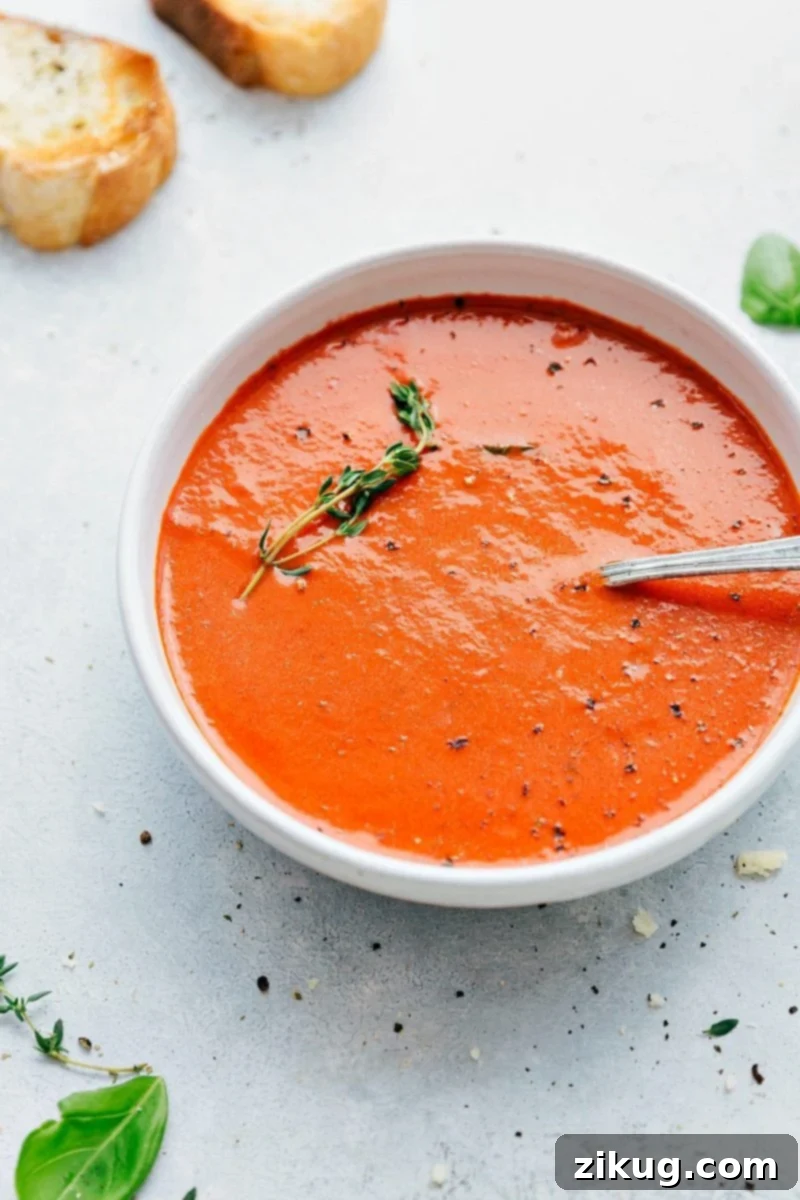 Homemade Tomato Basil Soup Recipe A steaming bowl of homemade Tomato Basil Soup, garnished with fresh thyme leaves, ready to be enjoyed.
