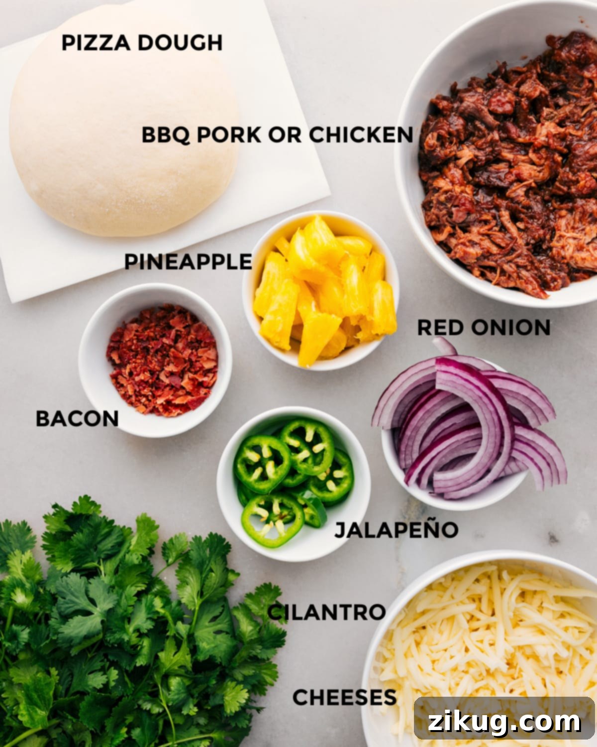 All the vibrant ingredients for this delicious BBQ Chicken Pizza are neatly prepped and arranged, showcasing fresh dough, succulent shredded chicken, sweet pineapple chunks, thinly sliced red onion, fiery jalapeño slices, a blend of Monterey Jack and Mozzarella cheeses, and crispy bacon bits, all ready for assembly.