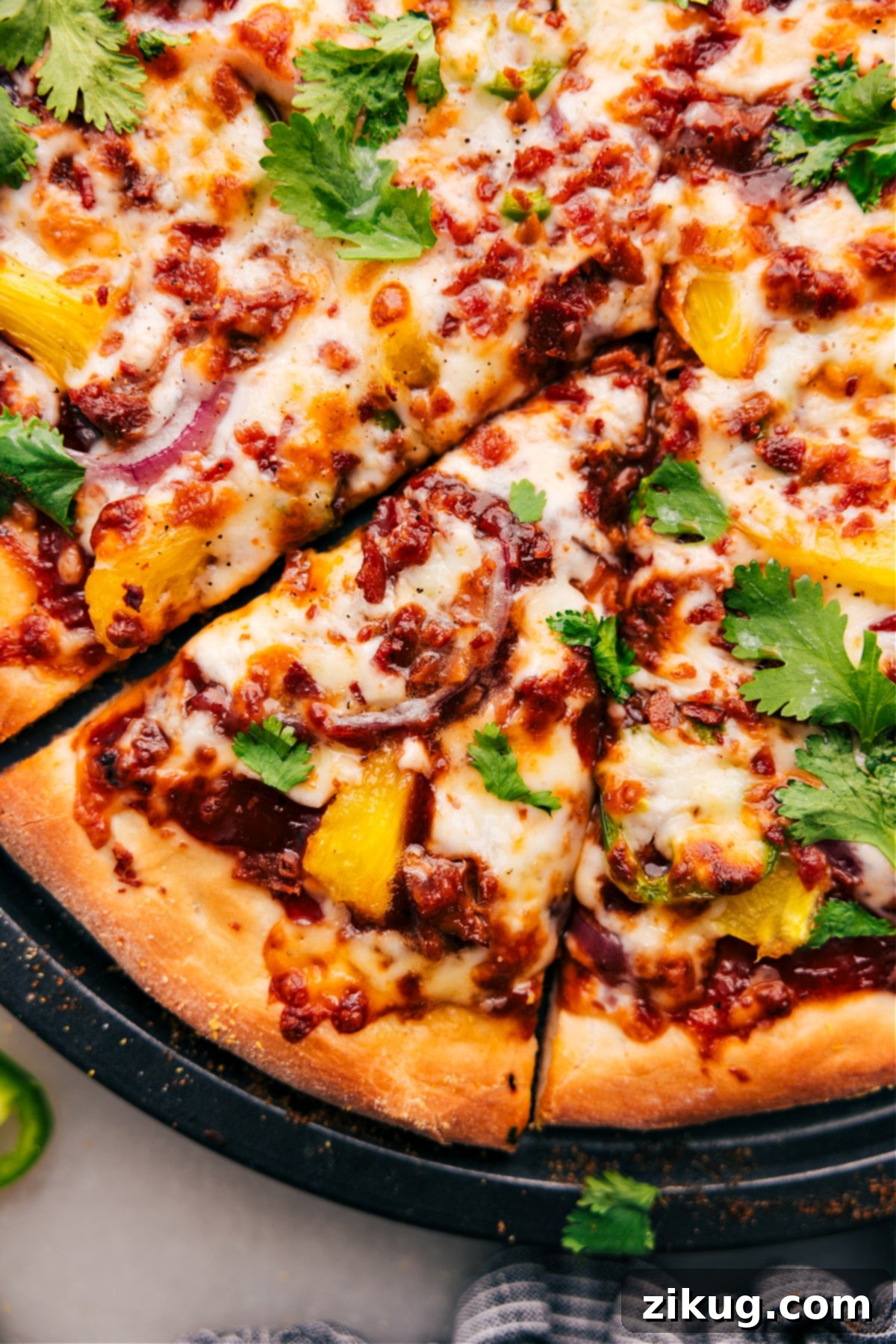 The enticing BBQ Chicken Pizza, just removed from the oven, still sizzling with melted cheese, expertly adorned with fresh cilantro and skillfully cut into perfect, mouthwatering slices, ready to be enjoyed immediately.