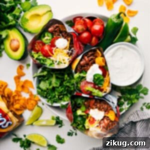 Close-up of a delicious Walking Taco served in a Frito bag, overflowing with seasoned ground beef, cheese, lettuce, and sour cream.