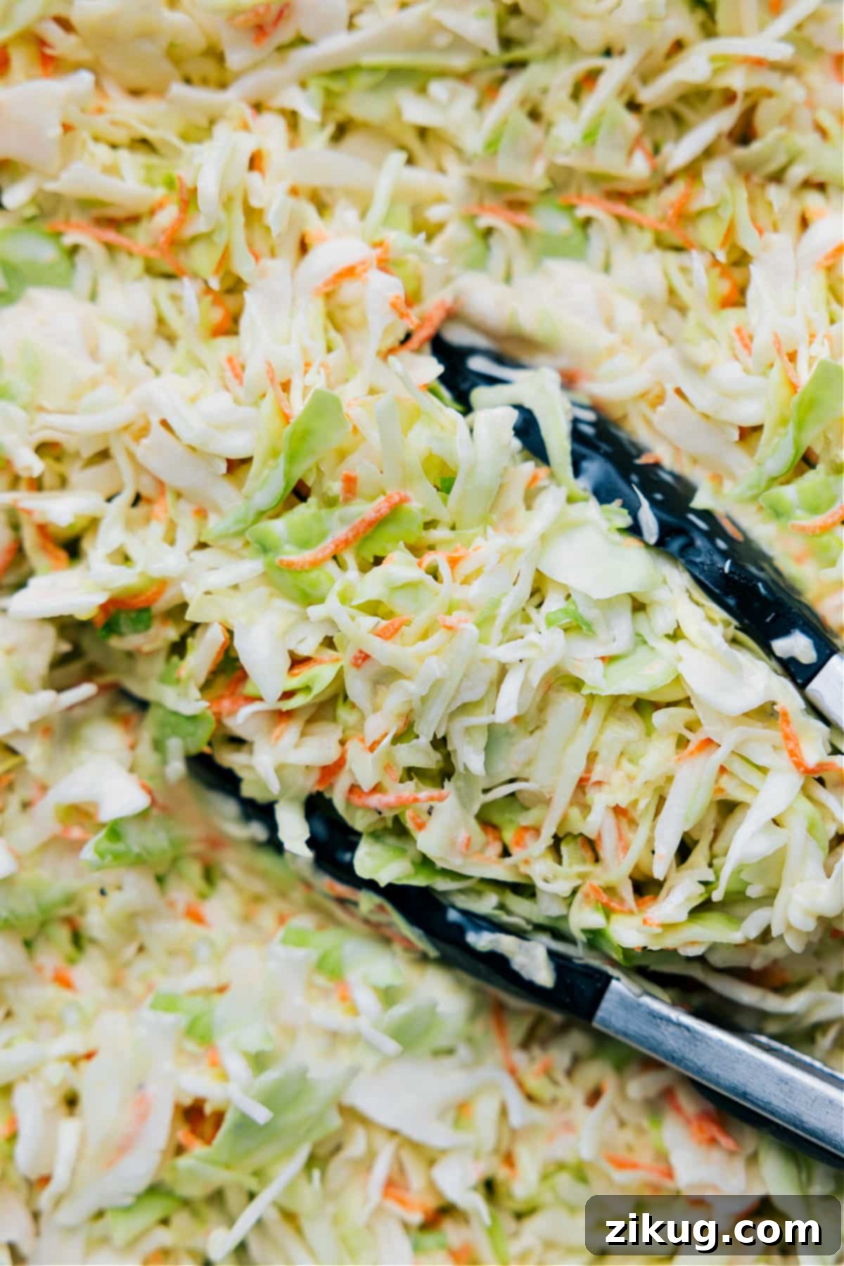 How To Make Chick-Fil-A Coleslaw Cabbage Finely shredded green cabbage and grated carrots are being gently folded into the luscious, creamy coleslaw dressing in a large bowl, ensuring an even coating.