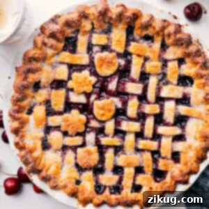 Close-up of a slice of cherry pie with a golden lattice crust, showcasing the rich, red filling.
