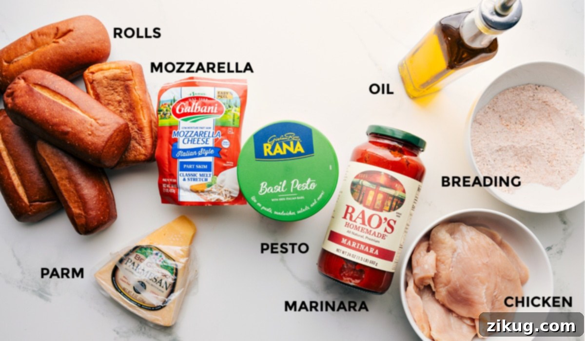 All the essential ingredients for a delicious Chicken Parmesan Sandwich, prepped and laid out for easy assembly: sturdy rolls, fresh mozzarella, grated parmesan, vibrant pesto, rich marinara, breading mixture, cooking oil, and pounded chicken cutlets.