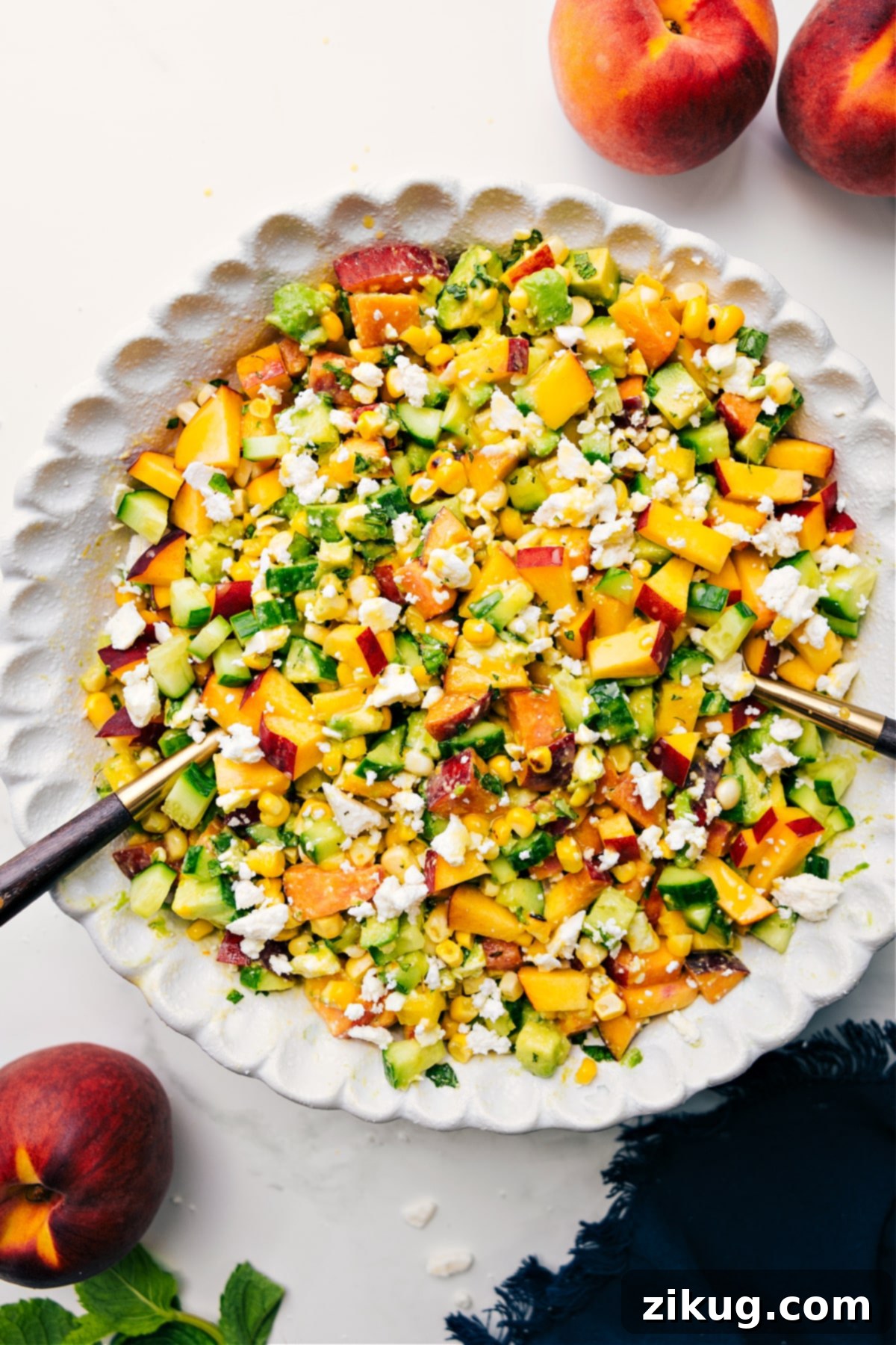 The Perfect Summer Salad: Peach Feta Salad Recipe A vibrant Peach Feta Salad tossed together in a large bowl, showcasing juicy peaches, grilled corn, avocado, feta, and fresh basil, ready to be served and enjoyed.