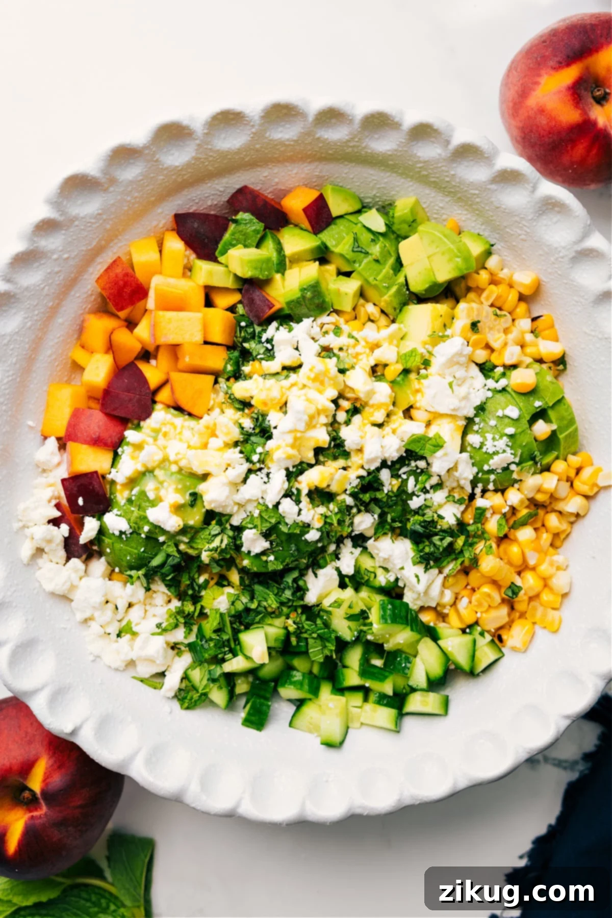 Delicious Peach Feta Salad Recipe Close-up of a large bowl filled with Peach Feta Salad, beautifully arranged and drizzled with a clear citrus dressing, ready to be tossed and enjoyed as a fresh summer meal.