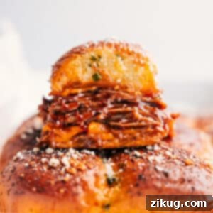 Freshly baked BBQ Pulled Pork Sliders, golden and bubbly with melted cheese, ready to be portioned and served.
