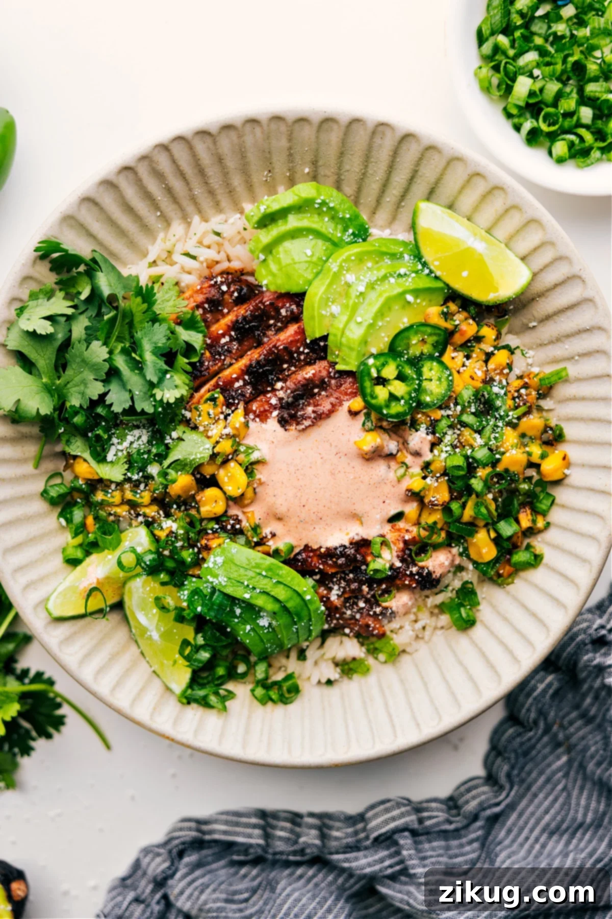 Fresh and Flavorful Street Corn Chicken Rice Bowl: Your New Favorite Dinner Street Corn Chicken Rice Bowl with avocado, cilantro, and creamy sauce, presented beautifully in a ceramic bowl.