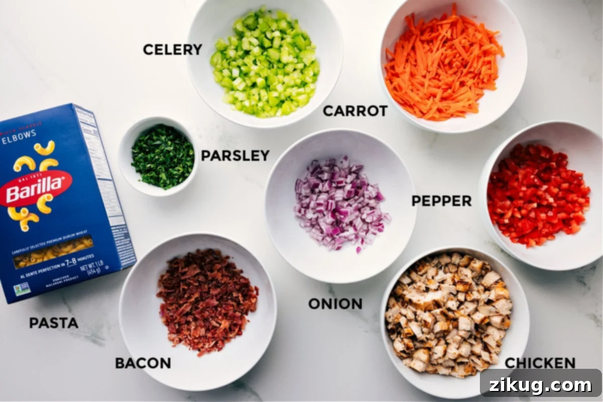 Essential Ingredients for Chicken Macaroni Salad A vibrant display of fresh ingredients for Chicken Macaroni Salad, prepped and laid out for easy assembly, including cooked macaroni, chopped parsley, sliced celery, shredded carrot, diced red onion, bell pepper, cooked chicken pieces, and crispy bacon bits.