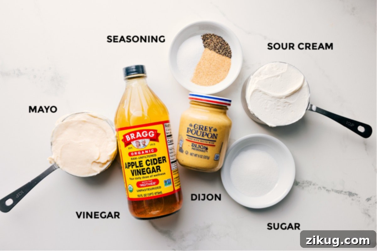 Dressing Ingredients for Chicken Macaroni Salad Individual ingredients for the creamy dressing of the Chicken Macaroni Salad, neatly arranged for preparation. This includes mayonnaise, sour cream, apple cider vinegar, Dijon mustard, granulated sugar, garlic powder, salt, and black pepper.