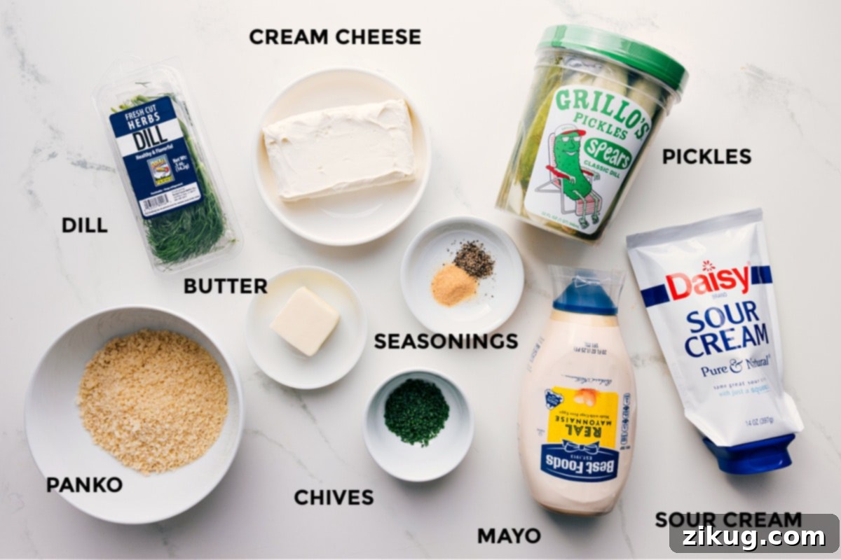 All fresh ingredients prepped for making homemade Fried Pickle Dip: fresh dill, cream cheese, panko breadcrumbs, butter, seasonings, chives, mayonnaise, sour cream, and a bowl of finely diced dill pickles.