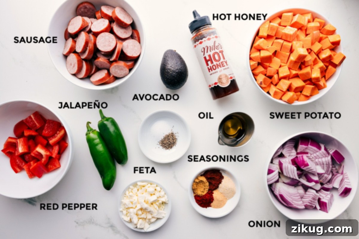 Ingredients In Sheet Pan Hot Honey Sausage & Veggies All the fresh ingredients for Sheet Pan Hot Honey Sausage & Veggies prepped, including red pepper, sausage, jalapeño, feta, avocado, seasonings, oil, hot honey, onion, and sweet potatoes.