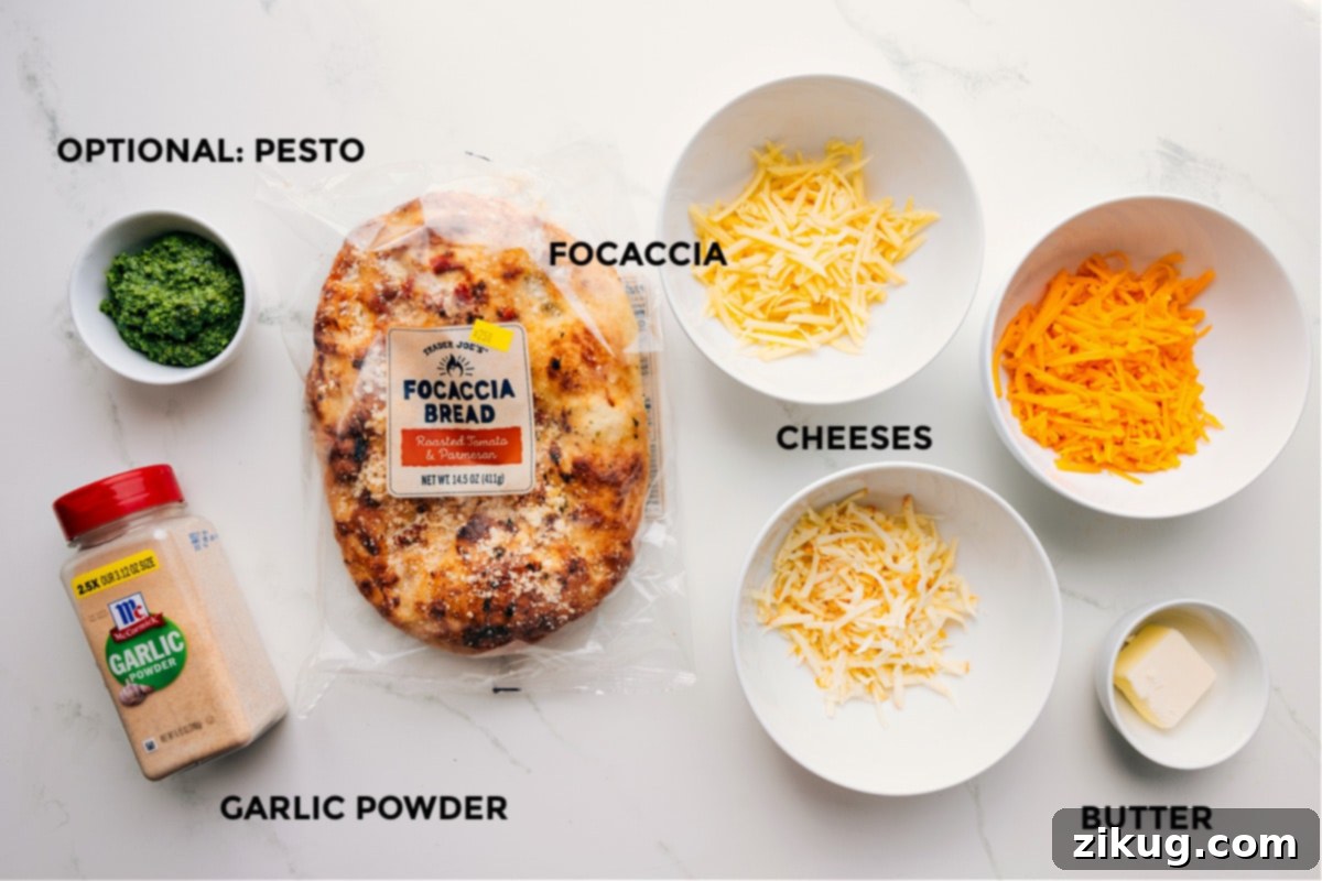 Ingredients In Focaccia Grilled Cheese Ingredients laid out for easy assembly: bread, cheeses, butter, garlic powder, and optional pesto.