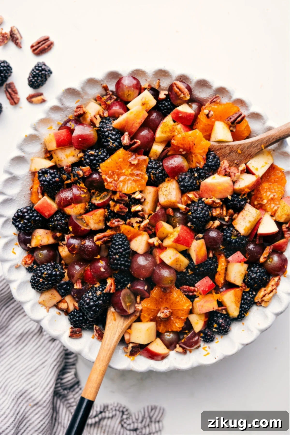 Easy And Flavorful Fall Fruit Salad Recipe A vibrant Fall Fruit Salad in a large glass bowl, beautifully tossed with sweet dressing, ready to be served and enjoyed at an autumn gathering.