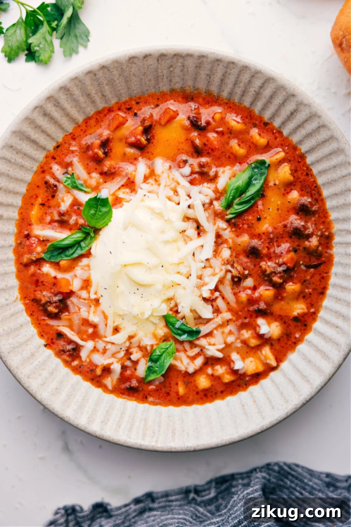 Pure Comfort Food: Easy Crockpot Lasagna Soup A beautifully presented bowl of Crockpot Lasagna Soup, generously topped with freshly grated Parmesan cheese and vibrant fresh basil, ready to be savored as the perfect comfort food meal.
