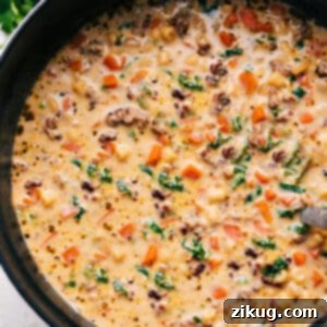 Delicious and hearty Creamy Parmesan Italian Sausage Soup, garnished with fresh herbs.