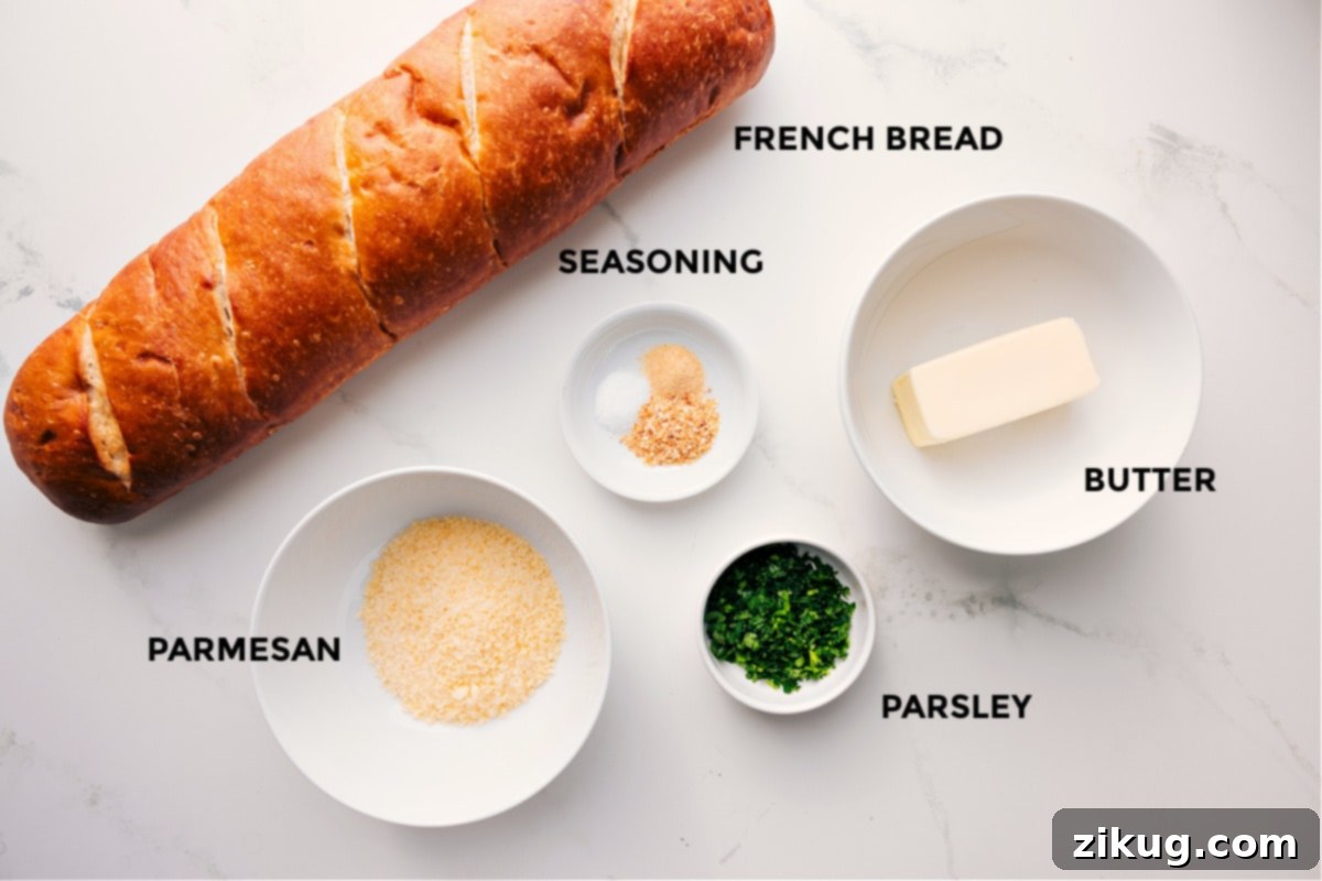 Ingredients In Garlic Bread Recipe All fresh ingredients for garlic bread, including French bread, Parmesan cheese, butter, garlic, and parsley, prepped for assembly.