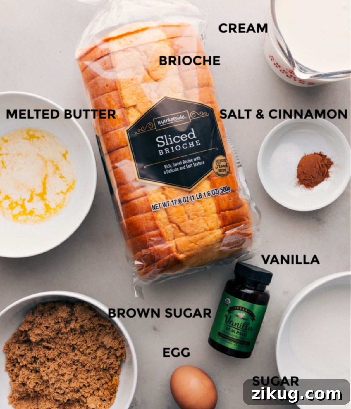Ingredients for Bread Pudding Recipe: Brioche, Butter, Sugar, Vanilla, Eggs and More Key ingredients for a delicious bread pudding recipe are neatly arranged on a rustic wooden surface. These include slices of brioche bread, a bowl of melted butter, light brown sugar, granulated white sugar, fresh eggs, a bottle of vanilla extract, and a container of heavy cream.