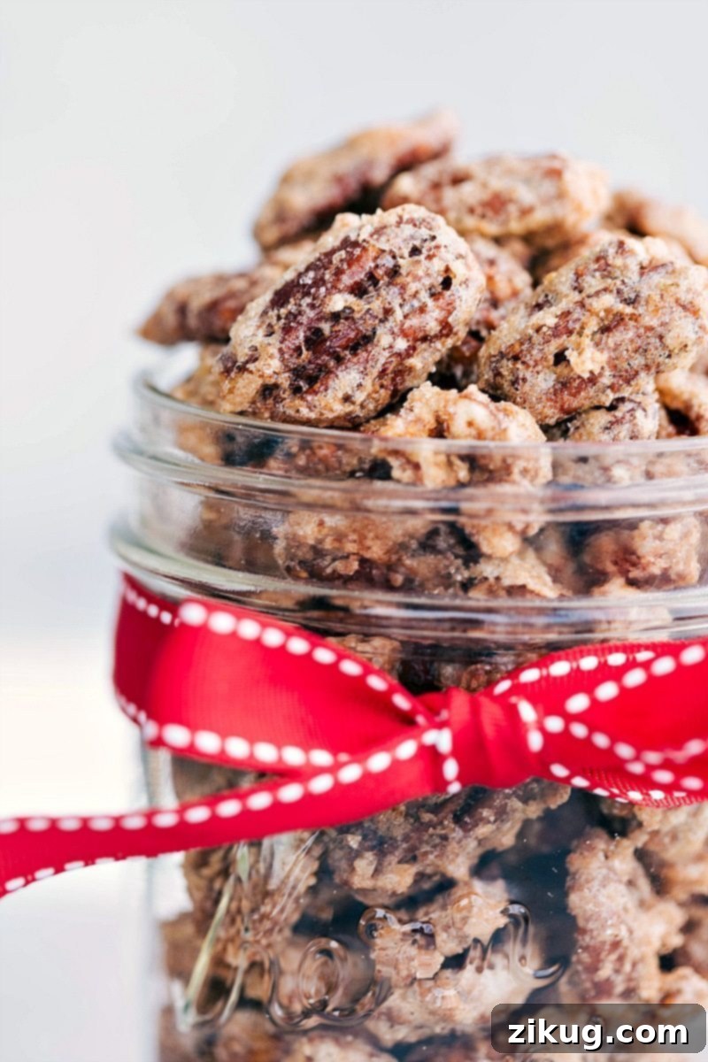 Candied Pecans Recipe In A Jar To Gift A charming glass jar filled with golden brown candied pecans, tied with a festive red ribbon, ready for gifting.
