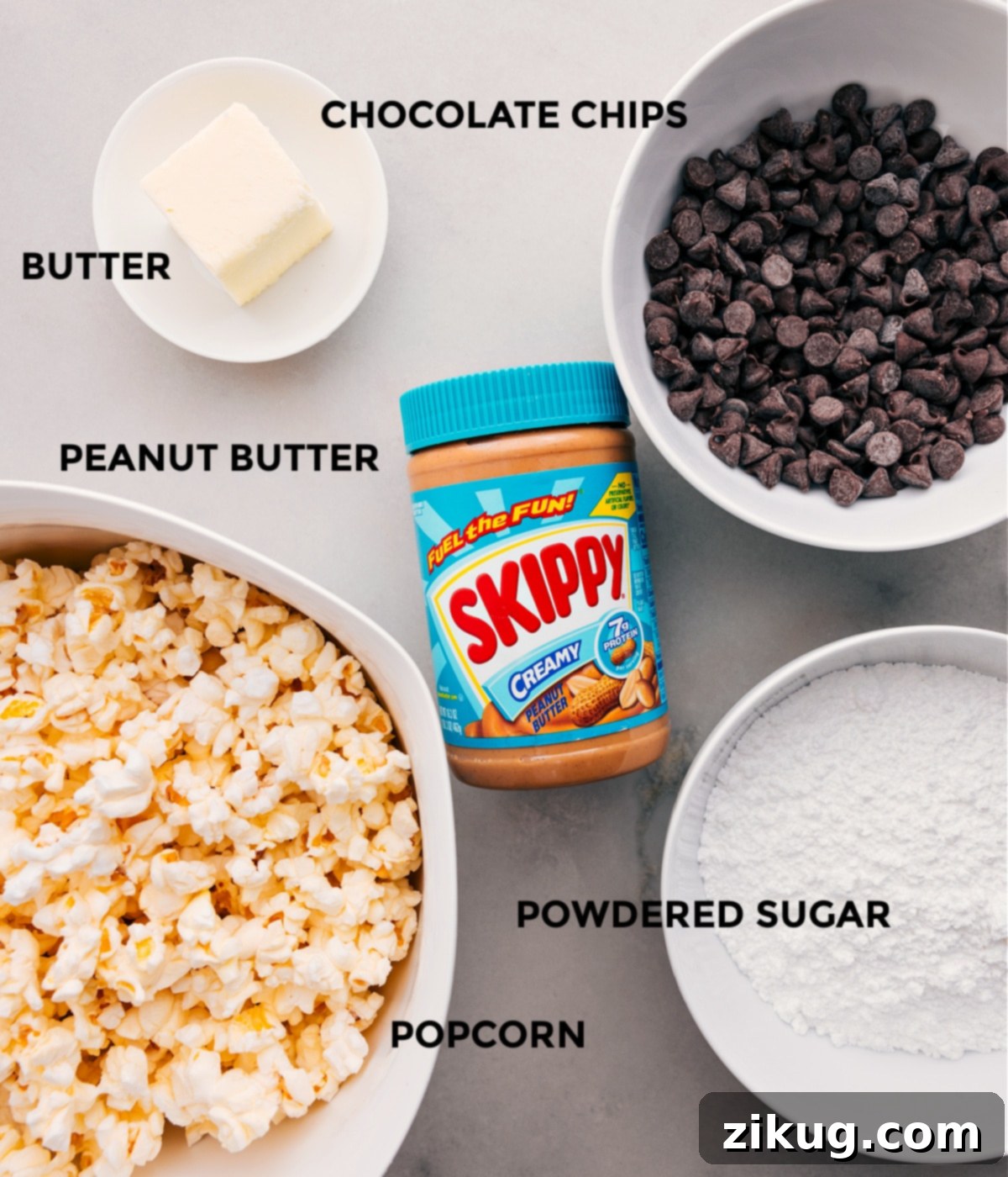 A selection of fresh ingredients including popped popcorn, creamy peanut butter, semi-sweet chocolate chips, butter, and powdered sugar, ready for Popcorn Puppy Chow.