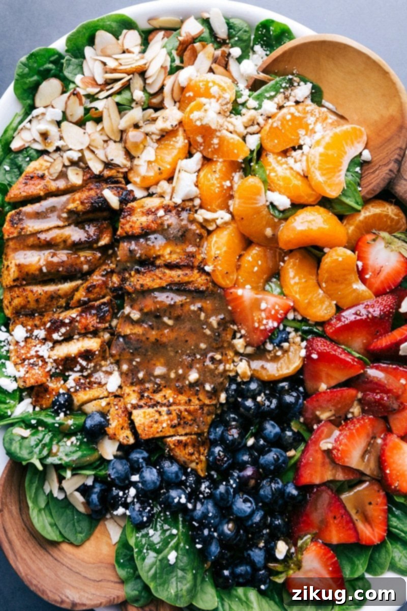 Deliciously Healthy Spinach Chicken Salad: Perfect Blend of Chicken, Spinach, Fruits, Dressing, and Nuts Completed spinach chicken salad showcasing sliced chicken, spinach, topped with fruit, dressing, and nuts, epitomizing a healthy and delicious meal.