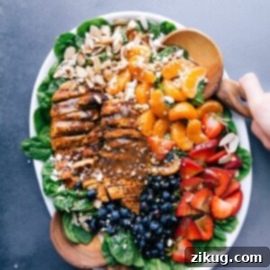 Vibrant Chicken Spinach Salad 2 Chicken spinach salad on a large platter, elegantly dressed and garnished with fresh fruit and nuts.