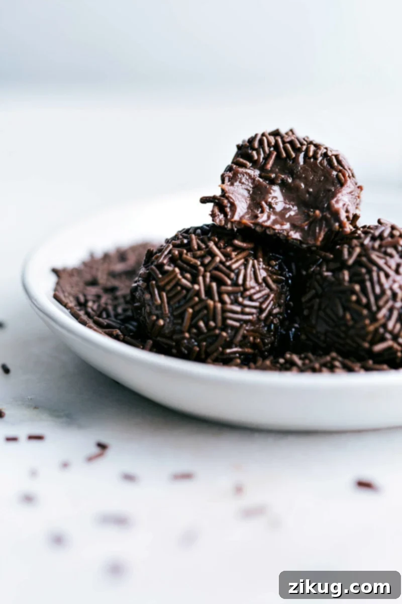 Delicious ultra-chocolatey and fudgy Brigadeiros ready to enjoy Close-up of a Brigadeiro with a bite taken out, revealing its rich, fudgy interior.