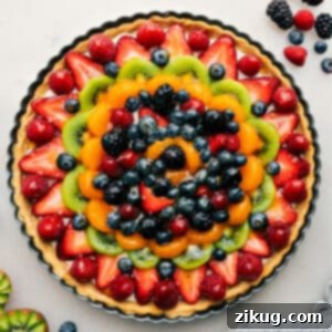 Beautifully decorated fruit pizza ready to be served, showcasing the vibrant colors of fresh fruits on a creamy frosting and cookie crust.