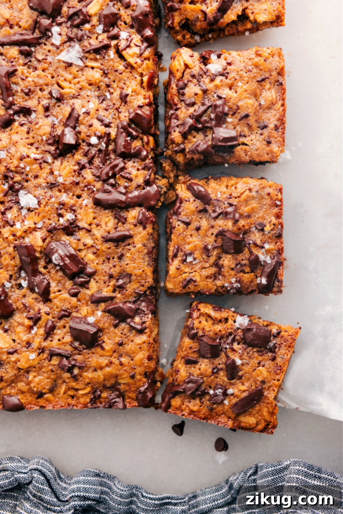 A perfectly baked and sliced batch of Soft-Baked Oatmeal Breakfast Bars arranged on a cooling rack, showcasing their golden-brown edges and soft centers, ready for enjoyment.