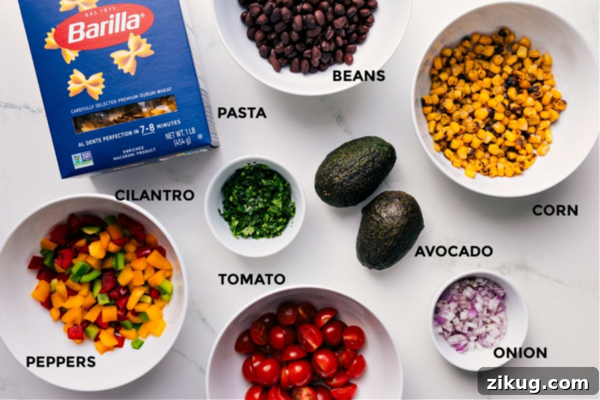 All the vibrant ingredients prepped and ready for assembly: pasta, grilled corn, black beans, diced bell peppers, cherry tomatoes, red onion, fresh cilantro, and a perfectly ripe avocado.