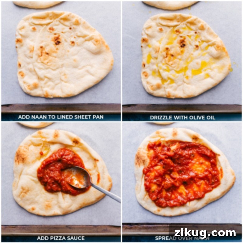 Naan flatbread on a sheet pan brushed with olive oil and spread with pizza sauce, ready for toppings.