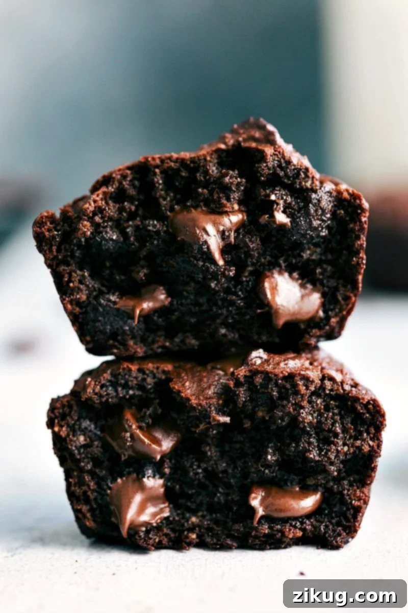 Irresistible Chocolate Peanut Butter Muffins with Gooey Chocolate Chips Chocolate peanut butter muffins, cut in half and stacked, revealing their soft interior with gooey chocolate chips.