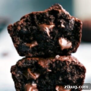 Chocolate peanut butter muffins, cut in half and stacked, revealing their soft interior with gooey chocolate chips.