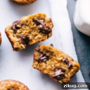 Peanut butter banana muffin broken open, revealing the delicious interior with melting chocolate chips.