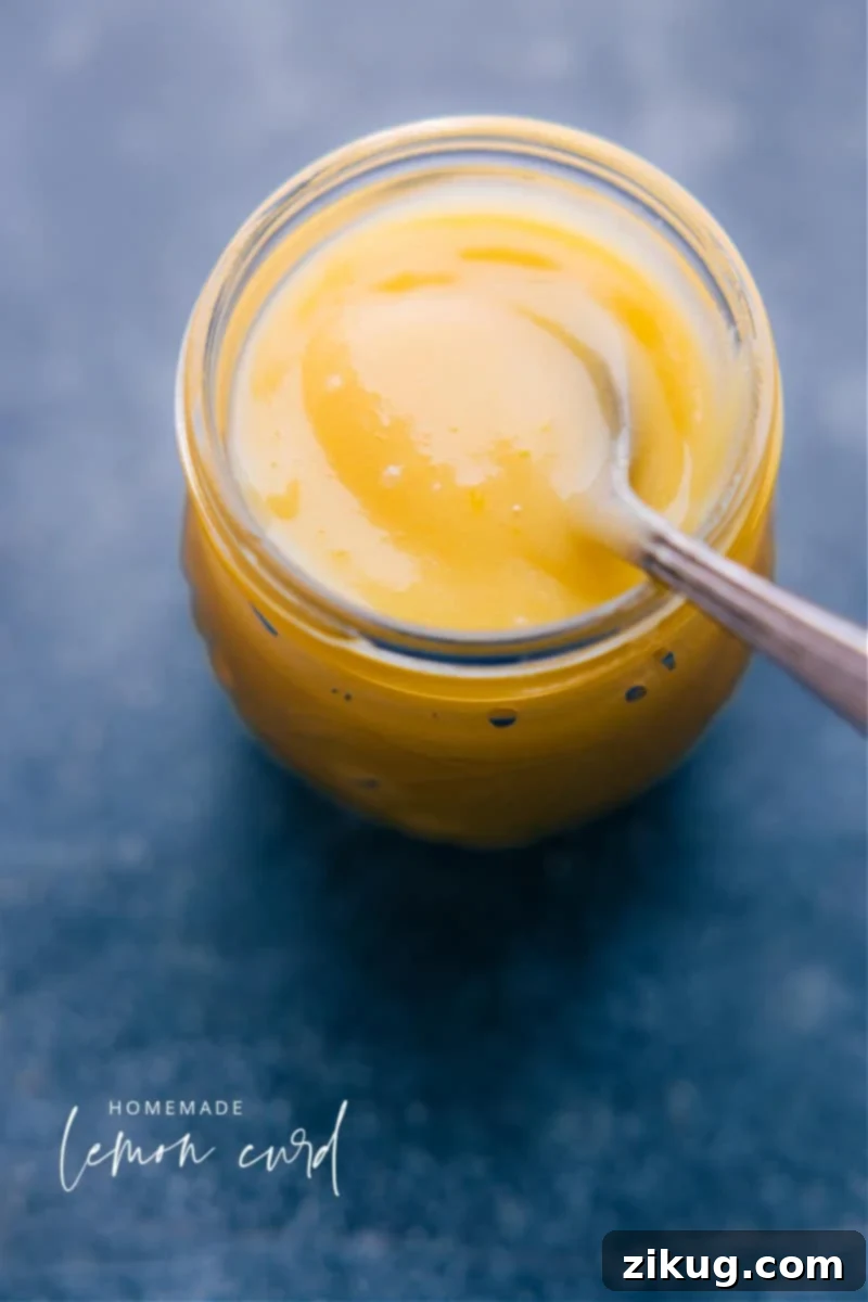 Lemon Curd is a delicious dessert spread and topping made with lemons, butter, sugar, and eggs. It's ideal for spreading on scones or biscuits, topping desserts with, or adding it to a stack of pancakes or crepes. While you can sometimes buy it from a store (near pie fillings or jams), there is truly nothing like homemade lemon curd! Recipe via chelseasmessyapron #dessert #best #quick #easy #simple #citrus #breakfast #brunch #lemon #curd Overhead image of Lemon Curd in a jar, with a spoon