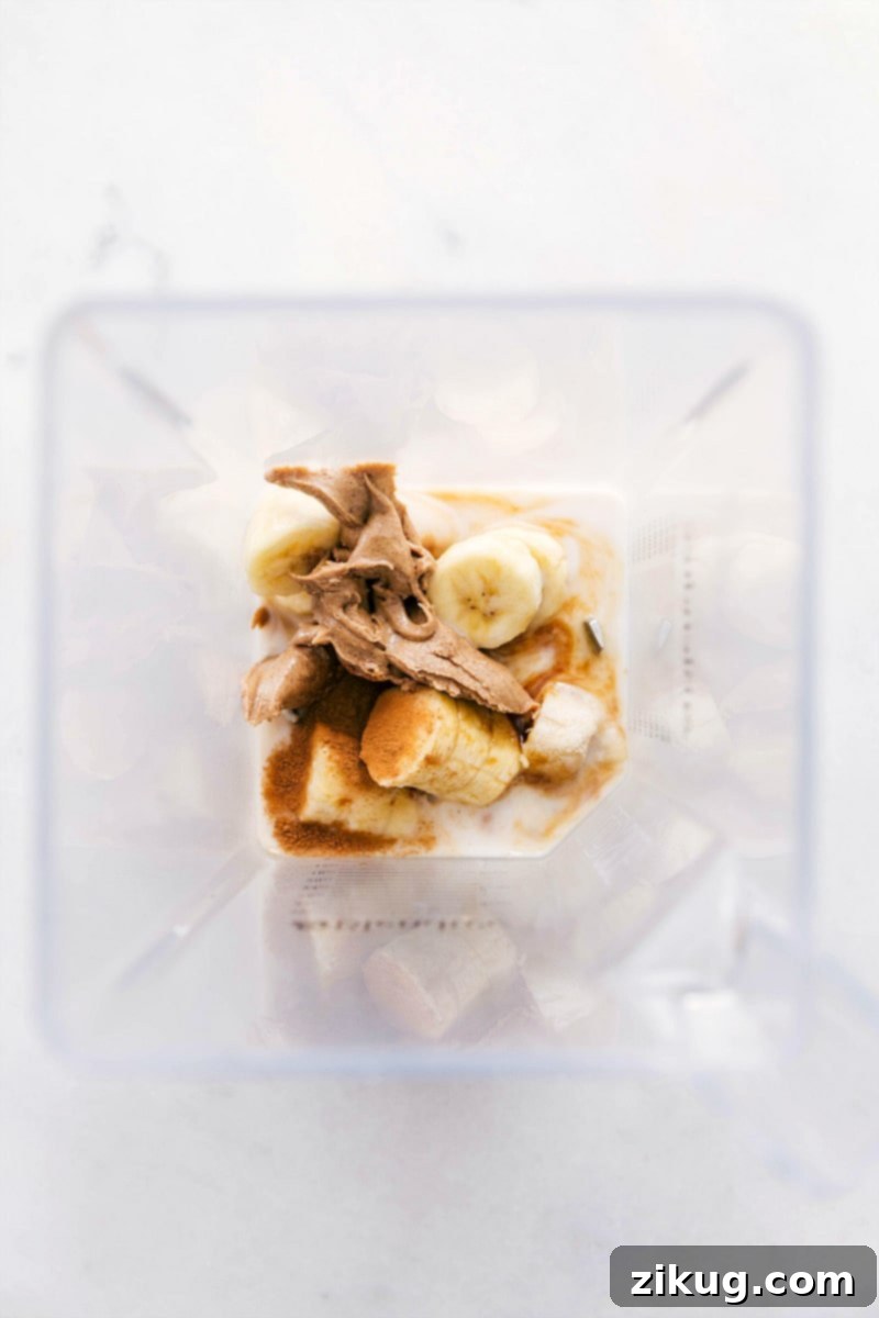 The Best Banana Smoothie Ingredients in Blender All five banana smoothie ingredients, including almond milk, frozen bananas, almond butter, vanilla extract, and cinnamon, are placed in a blender jar, ready to be processed into a delicious drink.